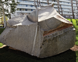 This sculpture by Jim Huntington appears to break the smooth contours of the gently rolling parkland, but looks organic to the setting, as if it had been there long before the buildings near it were built. The harmony of Night Shift with the landscape is consistent with Huntington’s sensibility. A rectangular plate of polished steel slices through the top of the large granite, echoing the surrounding environment — a combination of the natural and the manmade.