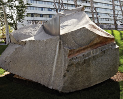 This sculpture by Jim Huntington appears to break the smooth contours of the gently rolling parkland, but looks organic to the setting, as if it had been there long before the buildings near it were built. The harmony of Night Shift with the landscape is consistent with Huntington’s sensibility. A rectangular plate of polished steel slices through the top of the large granite, echoing the surrounding environment — a combination of the natural and the manmade.